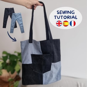 Peut inclure: Un sac fourre-tout en patchwork de denim composé de panneaux alternés bleu clair et gris anthracite foncé. Le sac présente deux longues bretelles et une poche extérieure centrée sur le devant. Le texte indique SEWING TUTORIAL.