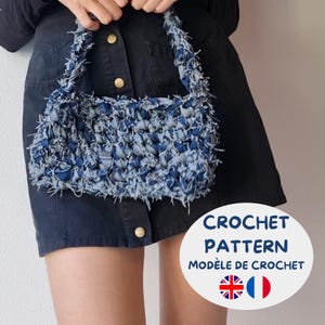 Può includere: Una borsa all'uncinetto in denim blu con forma rettangolare e una trama sfrangiata. La borsa ha un manico realizzato con lo stesso materiale. L'immagine include anche il testo "CROCHET PATTERN" e "MODELE DE CROCHET".