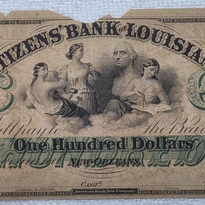 May include: A vintage 100 dollar banknote from The Citizens' Bank of Louisiana, New Orleans. The tan paper features black ink illustrations of figures, portraits, and the text One Hundred Dollars, with the number 100 in the top corners.