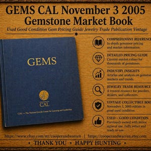 May include: A vintage "GEMS" gemstone market book from November 3, 2005, in good used condition. The navy blue book has gold lettering and is displayed on a wooden background. The book is a jewelry trade publication.
