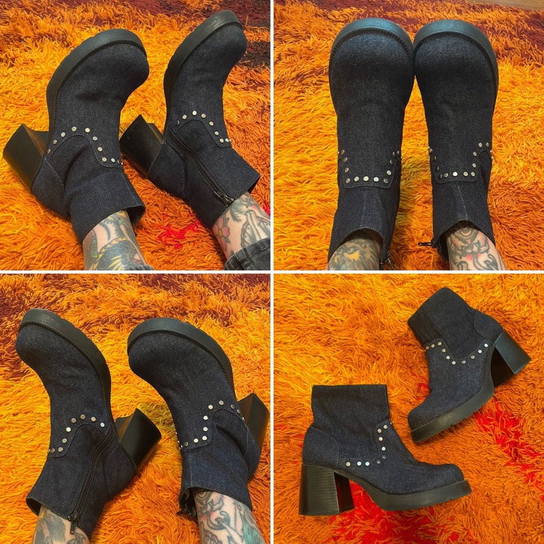 May include: A pair of denim ankle boots with silver studs. The boots have a chunky heel and a pointed toe. The boots are shown on a model wearing them on both feet.