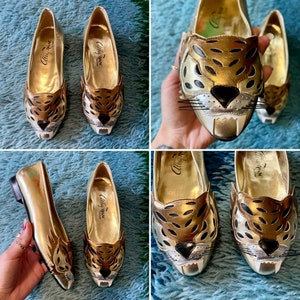 May include: Gold flats with a leopard print design and a tiger face on the toe. The shoes say "Alice + Olivia" on the inside.