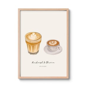 Op de afbeelding: Een ingelijste kunstdruk met een digitale illustratie van een hoog glas latte en een klein koffiekopje op een schoteltje, beide met hartvormige latte art. Onder de drankjes staat de tekst Richard & Olivia en de datum 09.10.2026.