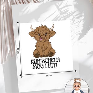 Könnte beinhalten: Eine weiße Karte mit einer Illustration einer braunen Highland-Kuh, die die Zunge herausstreckt. Die Karte ist 15 cm hoch und 10 cm breit, mit dem Text "KUH'SCHELN MOG I NIT!".