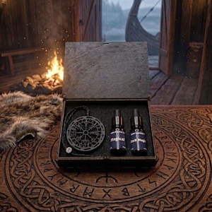 May include: A dark wooden box set containing a compass pendant and two small bottles labelled "Magical" and "Dark Magic." The set is presented on a carved wooden surface, with a Viking ship visible in the background. A small fire burns nearby.