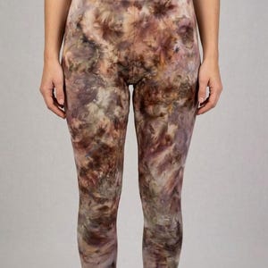 May include: Full-length leggings with a tie-dye pattern in shades of brown, purple, and cream. The leggings have a high waist and a form-fitting design. The fabric appears soft and comfortable.
