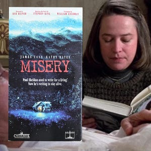 May include: A VHS tape for the movie "Misery" with James Caan and Kathy Bates. The cover features a snowy mountain scene with a house and the title in red. The text reads "Paul Sheldon used to write for a living. Now he's writing to stay alive."