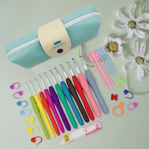 May include: A crochet kit with a variety of colorful crochet hooks, stitch markers, and a measuring tape. The kit includes a light blue zippered case with a mustache logo and the text "THE GREATEST HAPPINESS IN LIFE".