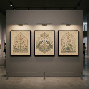 Könnte beinhalten: Drei gerahmte rechteckige Wandbilder an einer grauen Wand, jedes mit beigem Hintergrund und detaillierten botanischen Illustrationen von rosa Lotusblüten, grünen Blättern und zwei blauen Pfauen auf dem mittleren Bild.