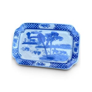 Puede incluir: Una bandeja rectangular de cerámica con un patrón de transferencia azul y blanco. El centro representa un paisaje con árboles, caballos y figuras. El borde está decorado con un patrón de rejilla cruzada y motivos florales sobre fondo blanco.