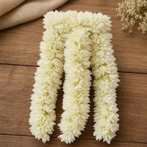 May include: A decorative garland composed of three dense, parallel strands of off-white, layered flower-like petals. The individual blossoms are tightly packed along each stem, creating a uniform, textured, and cylindrical appearance throughout.