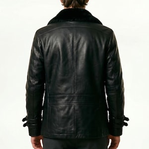 May include: Black leather jacket with a black fur collar. The jacket has a double-breasted design with two rows of buttons, two side pockets, and adjustable cuffs. The jacket is a classic style.
