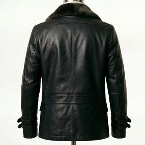 May include: Black leather jacket with a faux fur collar. The jacket has a double-breasted design, two front pockets, and adjustable cuffs. The back view shows a tailored fit, suitable for cold weather.