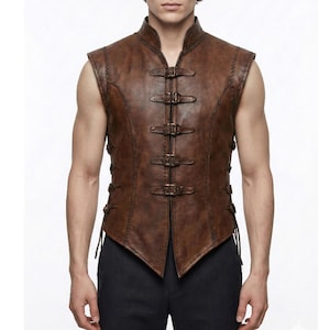 Peut inclure: Un gilet sans manches en cuir marron avec un col montant et plusieurs fermetures à boucle sur le devant. Le gilet présente des coutures décoratives et des lacets latéraux, pour une esthétique médiévale ou fantastique.