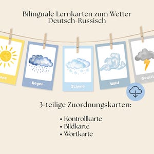 May include: Five rectangular educational cards hanging on a string with wooden clips, featuring watercolor weather illustrations and labels in German and Russian. The text reads: "Bilinguale Lernkarten zum Wetter Deutsch-Russisch" and "3-teilige Zuordnungskarten: Kontrollkarte, Bildkarte, Wortkarte".