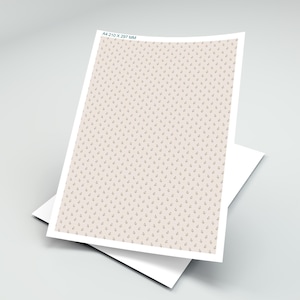 Op de afbeelding: A4 210 x 297 mm vel papier met een herhalend patroon van kleine, gestileerde bloemmotieven in een gedempte bruine kleur op een lichtbeige achtergrond. Het papier is gelaagd op een wit vel.