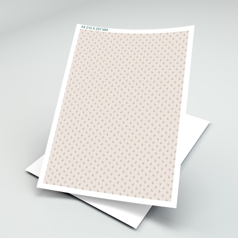 Op de afbeelding: A4 210 x 297 mm vel papier met een herhalend patroon van kleine, gestileerde bloemmotieven in een gedempte bruine kleur op een lichtbeige achtergrond. Het papier is gelaagd op een wit vel.