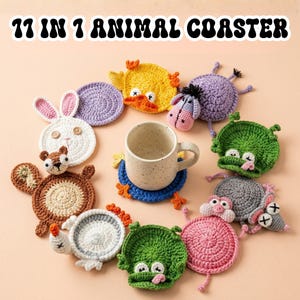 May include: A set of eleven handmade crochet animal coasters in various colours and designs, including a bunny, duck, squirrel, and pig. A ceramic mug sits on a blue coaster. The text "11 IN 1 ANIMAL COASTER" is at the top.