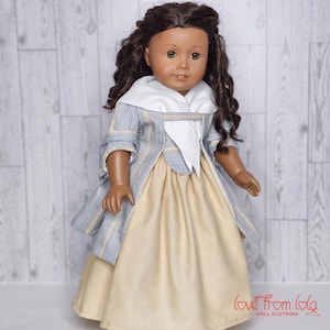 May include: A doll wearing a blue and white striped dress with a white collar and a yellow skirt. The doll has brown hair and brown eyes. The doll is standing on a white wooden background. The text "love from lola doll clothing" is visible in the bottom right corner of the image.