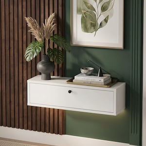 Puede incluir: Una taza de cerámica blanca con un asa negra y el texto "But First, Coffee" en negro, con una fuente de estilo manuscrito. La taza está sobre una superficie blanca.