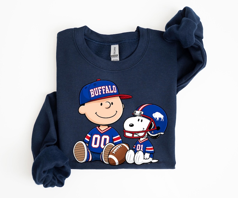 A navy blue sweatshirt with a graphic of two cartoon characters, one wearing a football jersey and the other a baseball cap, sitting together and smiling.