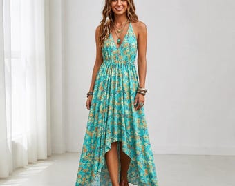 Puede incluir: Un vestido largo sin mangas de color turquesa vibrante con un patrón repetitivo de pequeñas flores amarillas y naranjas. El vestido tiene un escote en V profundo, una cintura ajustada y un dobladillo asimétrico más corto por delante y largo detrás.