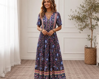 Puede incluir: Un vestido largo hasta los pies con una base azul marino oscuro y un vibrante estampado floral multicolor, mangas cortas, escote en V y una tapeta frontal con botones. El vestido incluye un diseño de falda escalonada con rayas horizontales.