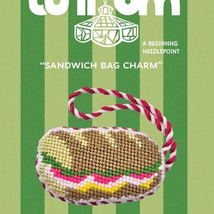 May include: A needlepoint kit titled Sunroom Stitchery #0003 Sandwich Bag Charm. The packaging features a green striped background and a finished sandwich-shaped charm with a red and white twisted cord. Includes 5x5 inch canvas and materials.