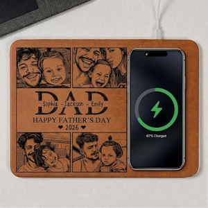 May include: A personalized brown leather wireless phone charger with family photos and the text "DAD Happy Father's Day 2026". A black smartphone is charging on the right side, displaying a green charging symbol and "67% Charged".