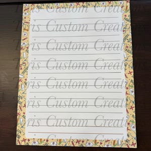 May include: A rectangular notepad featuring a white lined writing area surrounded by a yellow border decorated with a repeating pattern of medical icons including stethoscopes, nurse caps, and red crosses, with the text Toris Custom Creations.