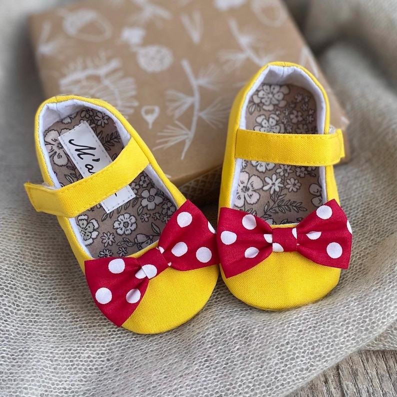 custom handmade Minnie mouse baby girl shoes and matching headband. Handmade soft sole shoes. Made from vibrant yellow solid fabric, finished with red bows. Matching bow headband available. Perfect for Minnie mouse themed outfits!