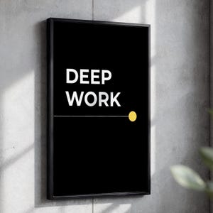 Op de afbeelding: Een rechthoekig wandkunstwerk met een zwarte achtergrond en de witte tekst DEEP WORK in een schreefloos lettertype. Een dunne horizontale witte lijn loopt vanaf de tekst naar een effen gele cirkel aan de rechterkant, in een zwarte lijst.