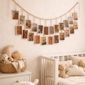 Peut inclure: Décoration murale avec une guirlande de perles en bois et des photos suspendues. Les photos rectangulaires ont un style vintage. Au-dessous, un lit bébé blanc et un panier en osier rempli de peluches créent une ambiance chaleureuse.
