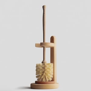 Könnte beinhalten: Ein Toilettenbürsten- und Halter-Set aus Holz. Die Bürste hat einen langen Griff und einen runden, borstenbesetzten Kopf. Der Halter ist aus hellfarbigem Holz gefertigt und hat eine kreisförmige Basis. Die Bürste ruht auf einer kleinen, runden, braunen Basis.