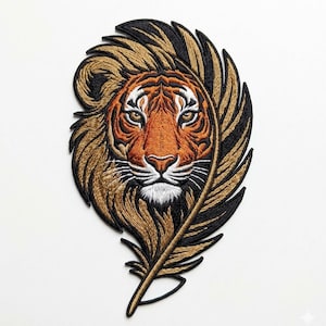 May include: Embroidered patch depicting a tiger's face within a feather. The tiger has orange and white fur with detailed facial features. The feather is brown and black, creating a striking contrast. Ideal for customising clothing or accessories.