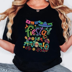 May include: A white ceramic mug with a black handle and the text "But First, Coffee" in a black, bold font. The mug is on a white surface.