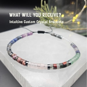 May include: A multi-colored crystal bracelet with a black adjustable cord. The bracelet features various gemstones in shades of pink, purple, blue, green, and clear. Text on the image reads: "WHAT WILL YOU RECEIVE? Intuitive Custom Crystal Bracelets."