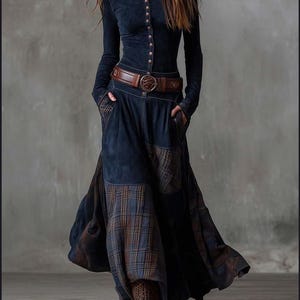 Può includere: Abito blu navy a maniche lunghe con bottoni e gonna ampia con inserti a quadri. Cintura in pelle marrone con fibbia decorativa. Completa l'outfit un paio di stivali marroni stringati. L'abito ha tasche.