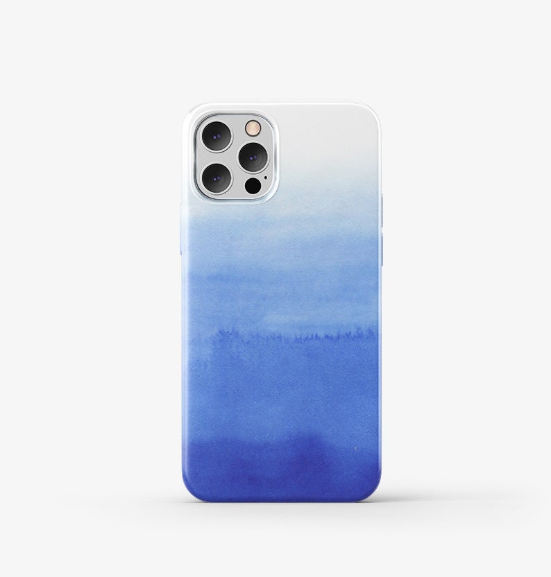 Puede incluir: Una funda transparente para tel&eacute;fono con un dise&ntilde;o de acuarela azul. El dise&ntilde;o se desvanece de un azul claro en la parte superior a un azul oscuro en la parte inferior.