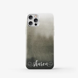 Puede incluir: Una funda transparente para tel&eacute;fono con un dise&ntilde;o de acuarela en negro y gris. La funda tiene una inscripci&oacute;n blanca que dice "sharon" con corazones a cada lado.