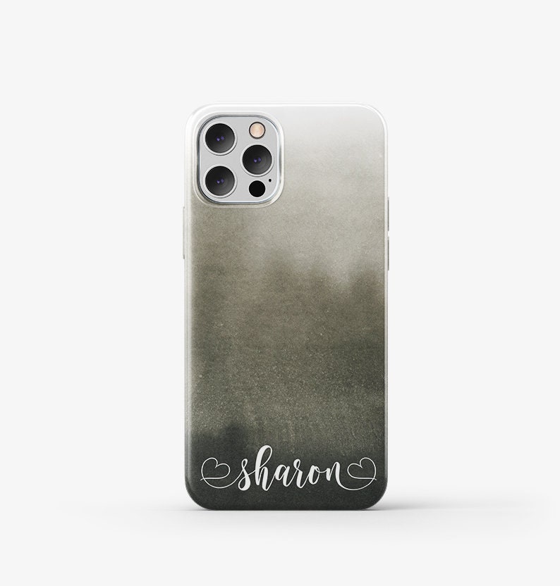 Puede incluir: Una funda transparente para tel&eacute;fono con un dise&ntilde;o de acuarela en negro y gris. La funda tiene una inscripci&oacute;n blanca que dice "sharon" con corazones a cada lado.