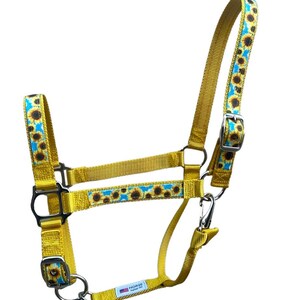 Pu&ograve; includere: Un guinzaglio giallo per cavalli con stampa di girasole. Il guinzaglio ha una fibbia argentata e un anello argentato. Il guinzaglio &egrave; in nylon.