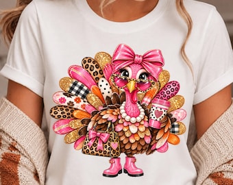 May include: A white t-shirt featuring a graphic of a turkey wearing a pink bow, heart-shaped glasses, a pearl necklace, and pink boots. The turkey holds a leopard print handbag and a coffee cup, with tail feathers in leopard, plaid, and floral patterns.