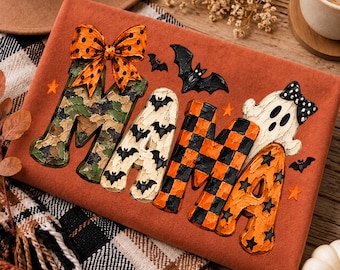 May include: An orange sweatshirt featuring the word MAMA in textured letters. The M has a camouflage pattern with an orange polka dot bow, the A has a bat print, the M has an orange and black checkerboard pattern, and the A has a ghost.