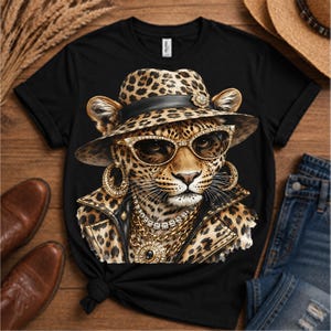 May include: A black t-shirt featuring a graphic print of a leopard wearing a leopard-print fedora, gold-rimmed sunglasses, large gold hoop earrings, a layered gold chain necklace with a central pendant, and a leopard-print jacket with a black collar.