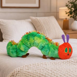 May include: A soft caterpillar toy in green, yellow, and red. The caterpillar has a red head with purple antennae and brown feet. The toy is designed to resemble a character from a children's book.