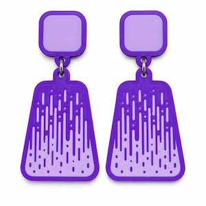 May include: A pair of purple earrings with a square top and a bell-shaped bottom. The earrings have a light purple square at the top and a design of vertical lines and dots on the bottom. The earrings are connected by a small metal ring.