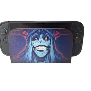 May include: A white ceramic mug with a black handle and the text "But First, Coffee" in a bold, black font. The mug is set against a blurred background, suggesting a cozy setting.