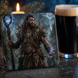 May include: Square coaster featuring a fantasy illustration of a warrior with a staff, surrounded by lightning and a forest. A glass of dark beer sits next to the coaster, with a lit candle and greenery in the background.