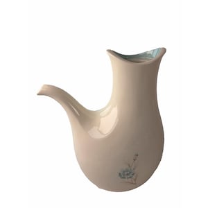 May include: A cream-colored ceramic pitcher with a long, curved spout and a wide, flared opening. The interior rim is finished in a soft light blue glaze. A small, delicate floral illustration featuring a blue flower is on the body.